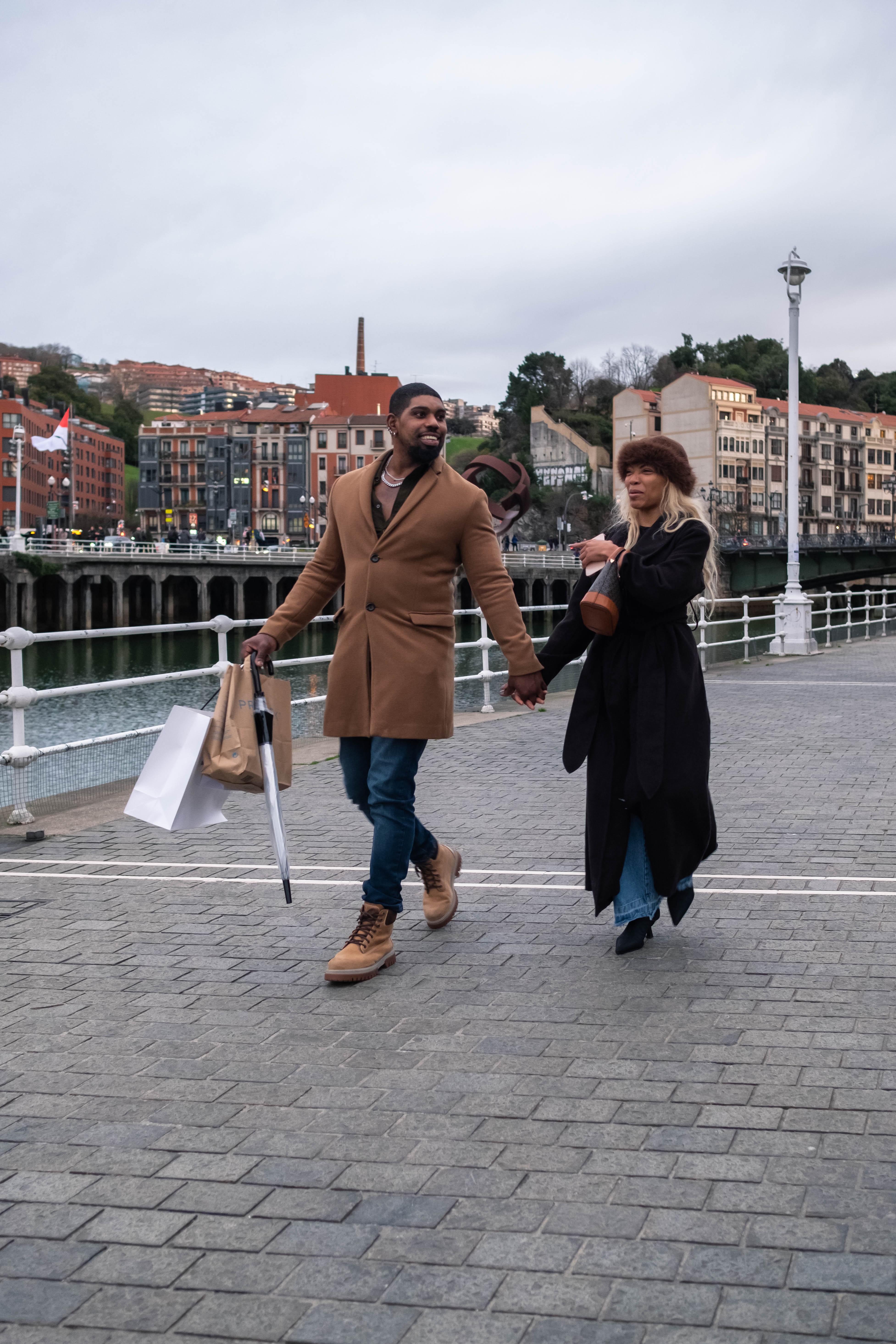 Una jovén pareja pasea junto a la Ría del Nervión. Bilbao, Bizkaia.