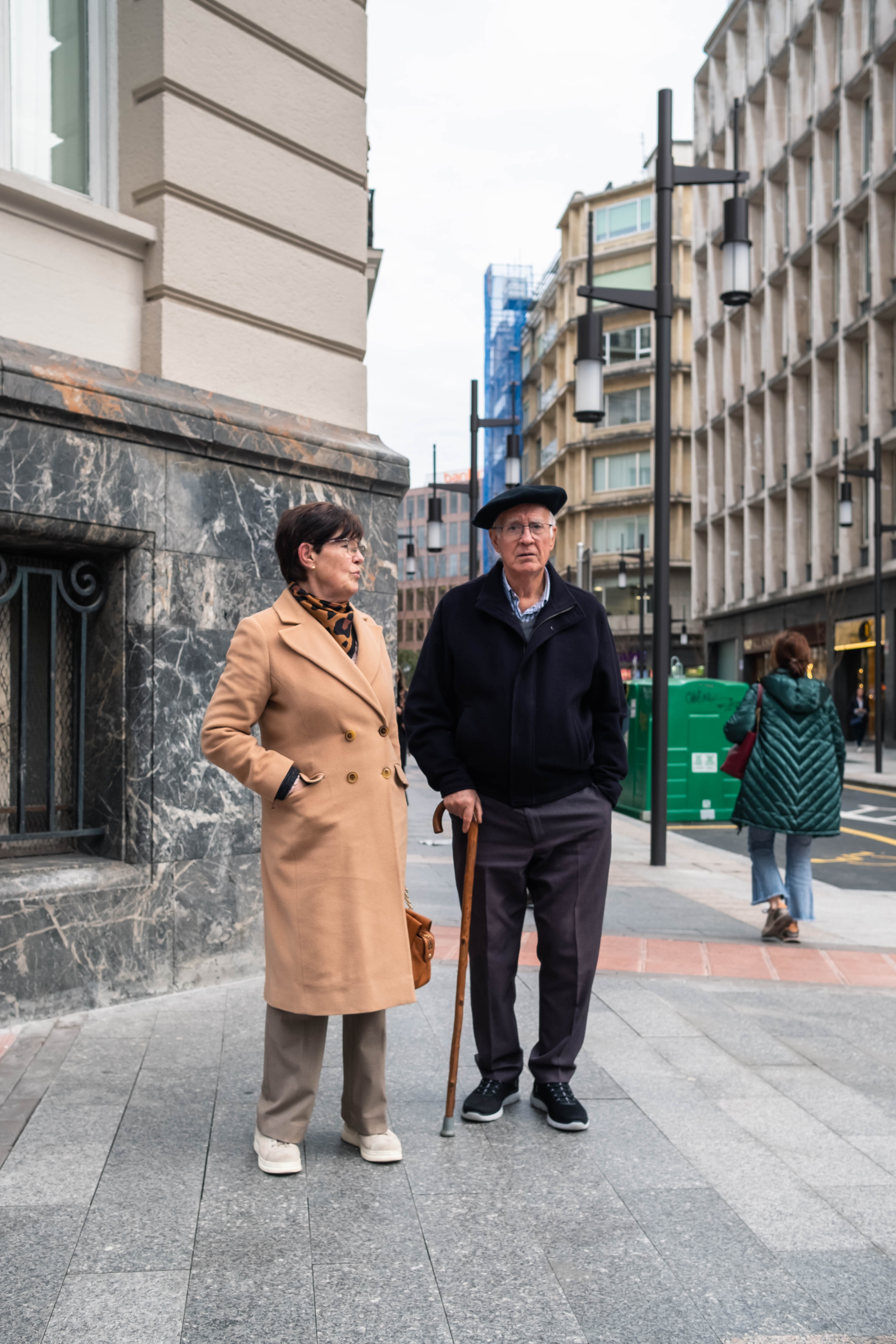 Una pareja de edad avanzada espera en un paso de peatones distrito del Ensanche. Bilbao, Bizkaia