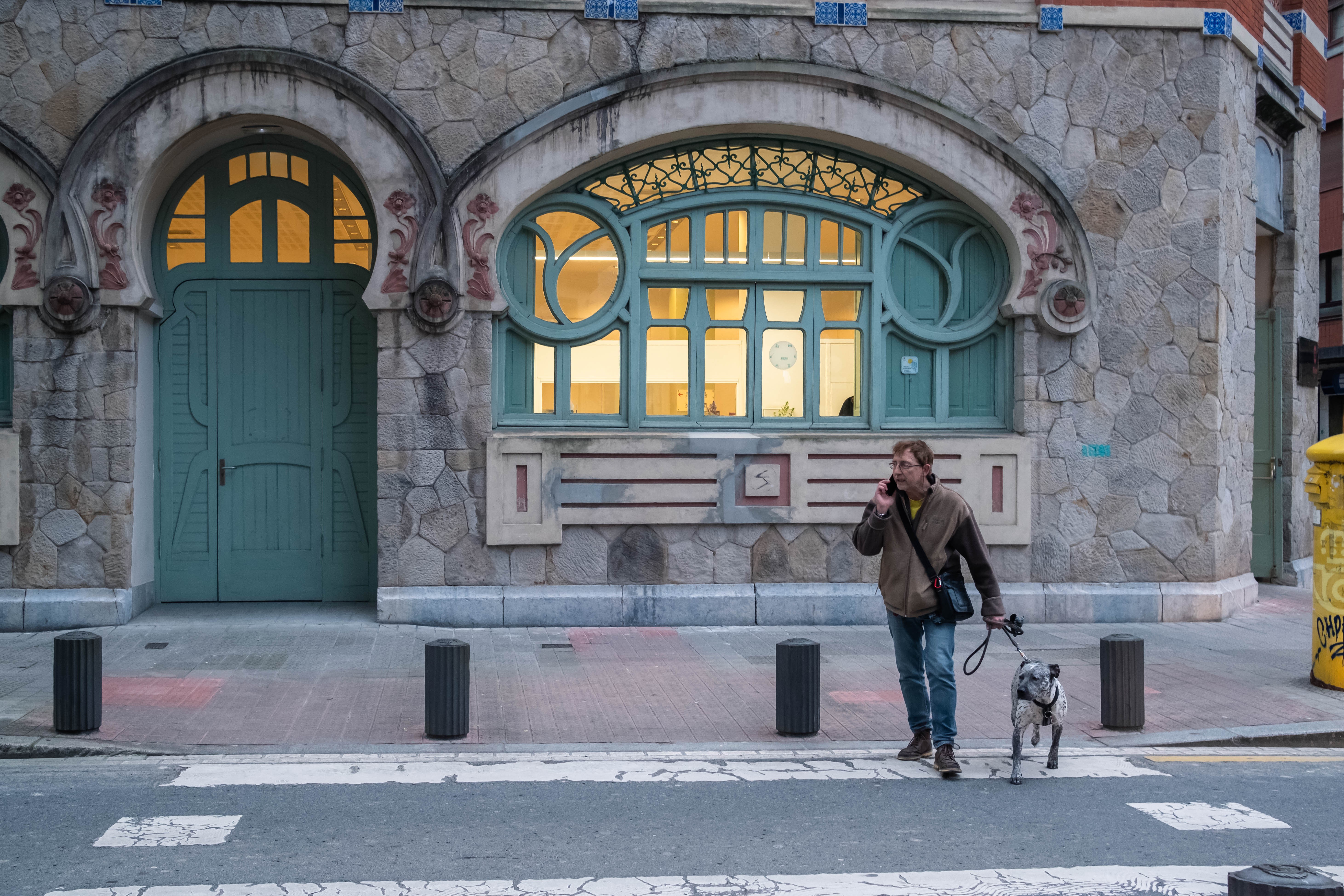 Un hombre pasea a su perro por una calle del barrio de Matiko. Bilbao, Bizkaia.