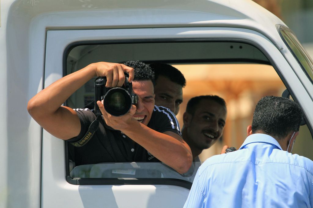 Fotoperiodista toma una fotografía desde un vehículo
